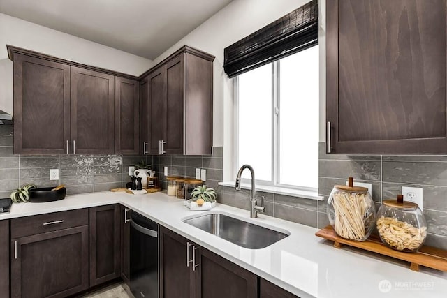 kitchen with dark brown cabinetry, a sink, dishwasher, light countertops, and decorative backsplash
