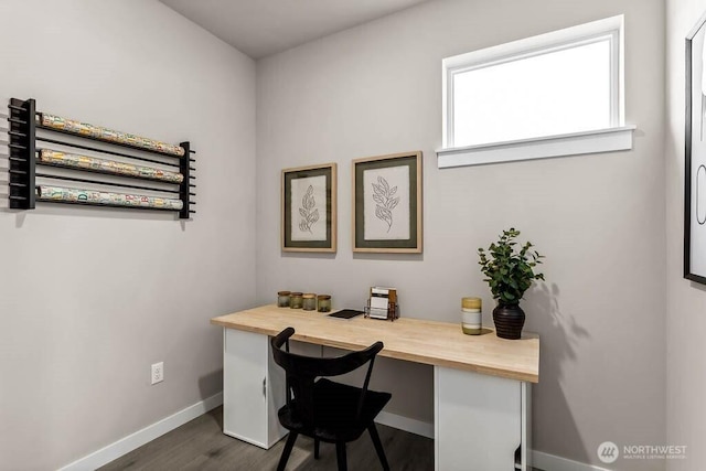 office with baseboards, built in study area, and dark wood-type flooring