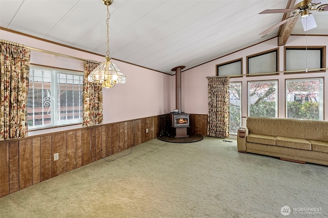 interior space with wainscoting, carpet floors, wooden walls, vaulted ceiling with beams, and a wealth of natural light