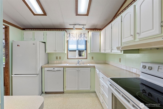 kitchen featuring white appliances, light countertops, under cabinet range hood, white cabinets, and a sink