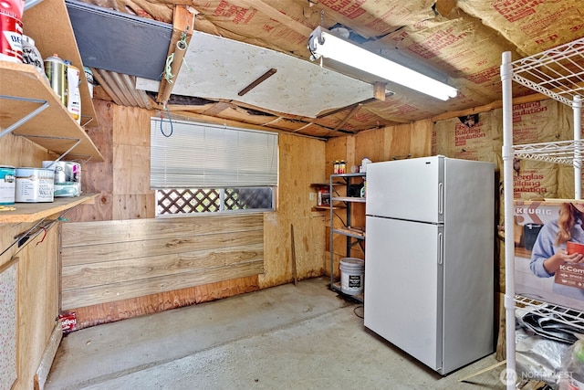 below grade area featuring freestanding refrigerator