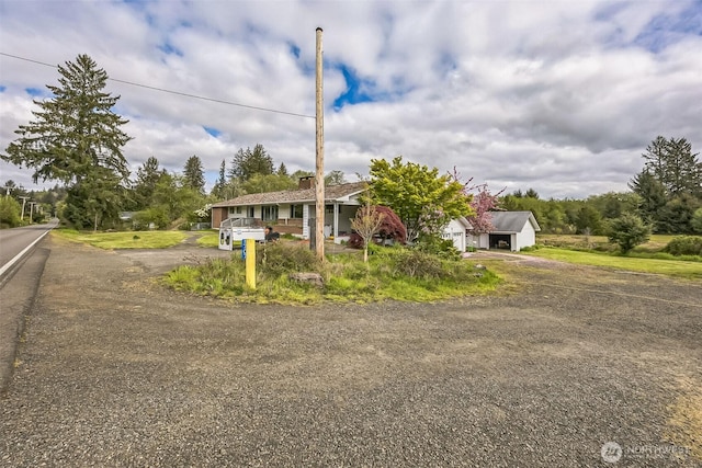 view of front of property with a garage and dirt driveway