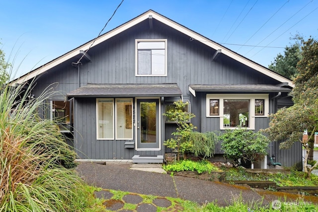bungalow-style home with roof with shingles