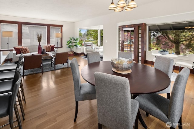 dining area featuring wood finished floors and a chandelier