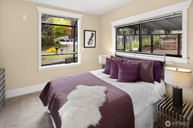 carpeted bedroom featuring baseboards and multiple windows