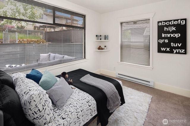 bedroom featuring baseboards, multiple windows, a baseboard heating unit, and carpet flooring
