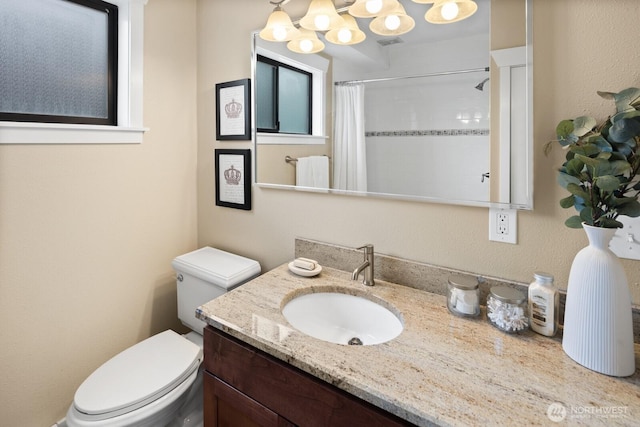 bathroom featuring vanity, visible vents, curtained shower, toilet, and a chandelier