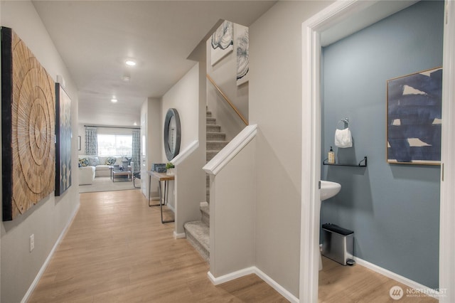 hall featuring baseboards, recessed lighting, wood finished floors, and stairway