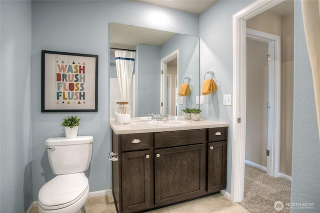 bathroom with vanity, baseboards, and toilet
