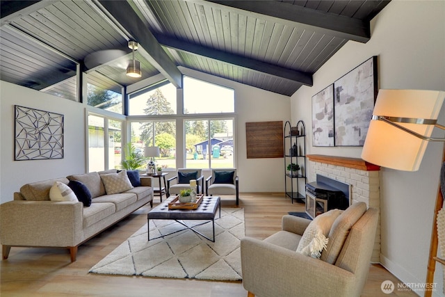 living room featuring vaulted ceiling with beams, baseboards, and wood finished floors