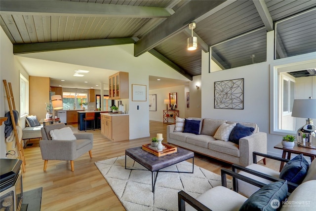living room featuring recessed lighting, vaulted ceiling with beams, and light wood finished floors