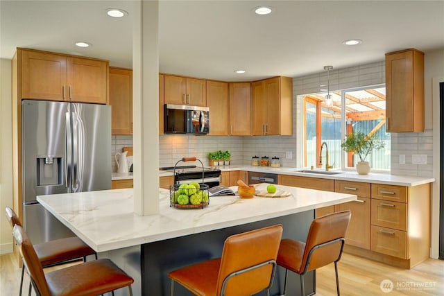 kitchen featuring a sink, recessed lighting, stainless steel appliances, and light wood-type flooring