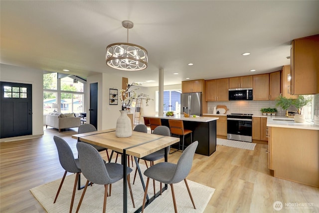 dining room with recessed lighting, light wood-type flooring, and a notable chandelier