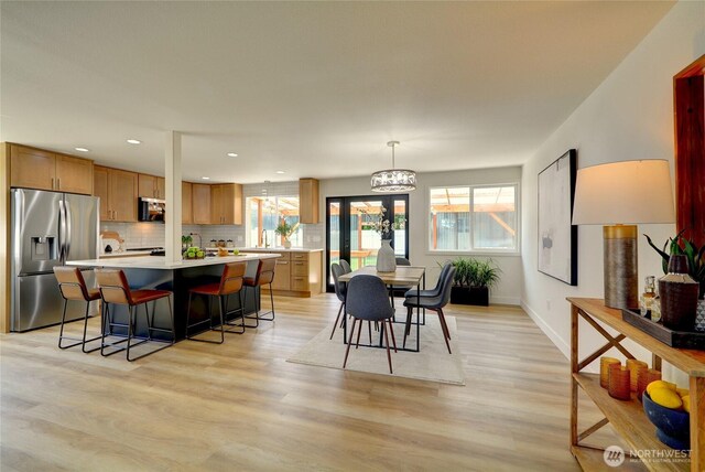 interior space featuring recessed lighting, baseboards, and light wood finished floors