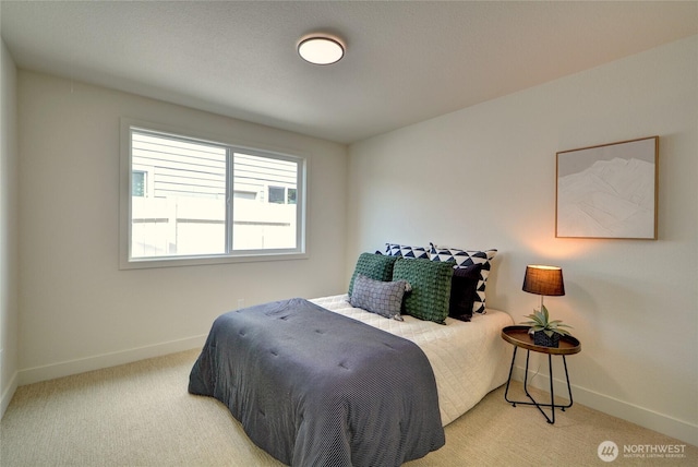 bedroom featuring baseboards and light carpet