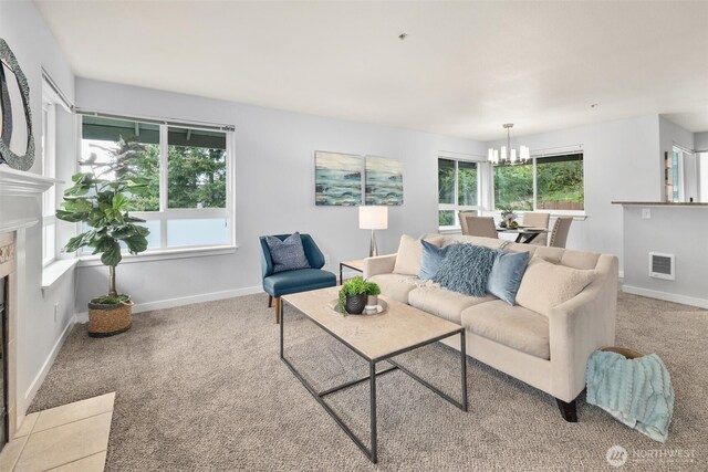 carpeted living area with a fireplace with flush hearth, baseboards, heating unit, and a notable chandelier