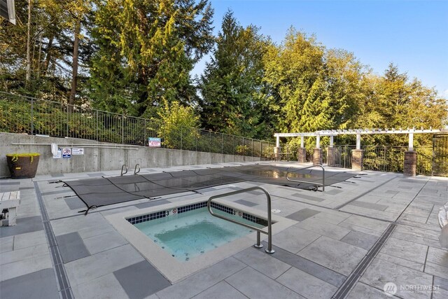 view of swimming pool featuring a patio, fence, and a community hot tub