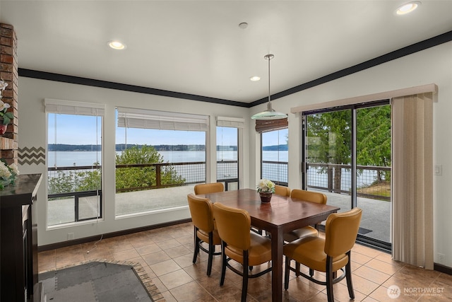 dining area with a water view, plenty of natural light, and tile patterned flooring