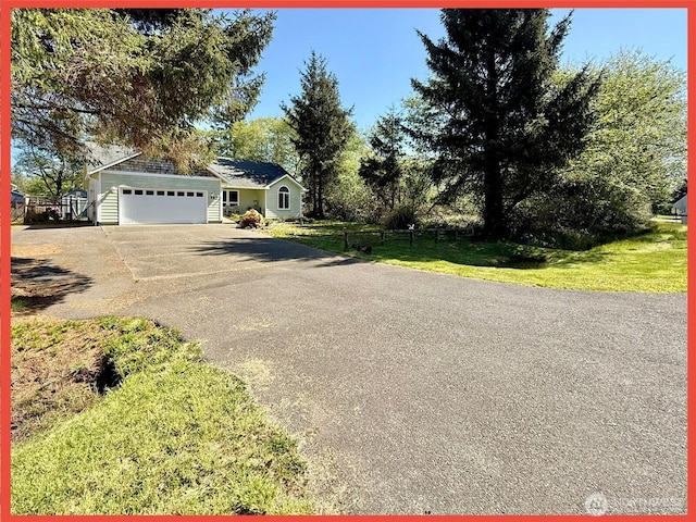 view of front of house with driveway, an attached garage, and a front yard