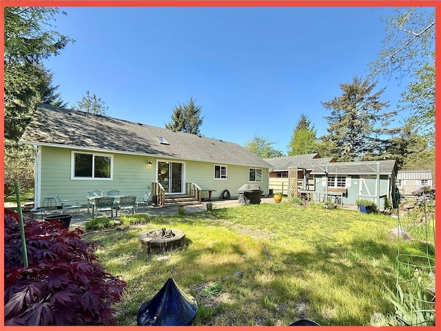rear view of house featuring an outdoor fire pit, a lawn, and a patio area