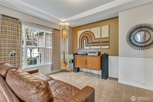 living area featuring crown molding, wainscoting, light carpet, and a healthy amount of sunlight