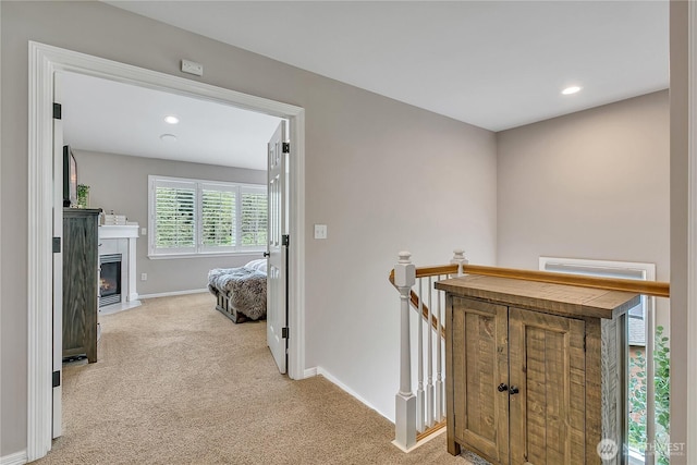 corridor with baseboards, carpet flooring, recessed lighting, and an upstairs landing