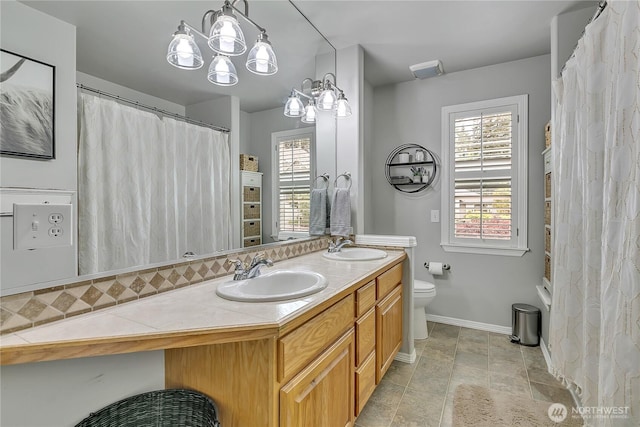full bathroom with baseboards, a sink, and a wealth of natural light