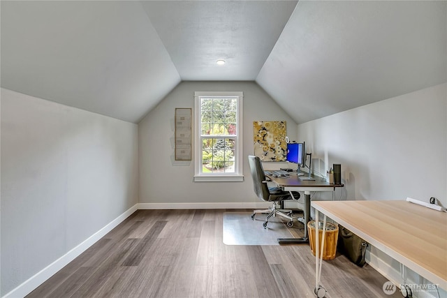 office space with baseboards, vaulted ceiling, and wood finished floors