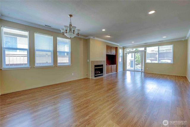 unfurnished living room featuring ornamental molding, a chandelier, light wood-style flooring, baseboards, and recessed lighting