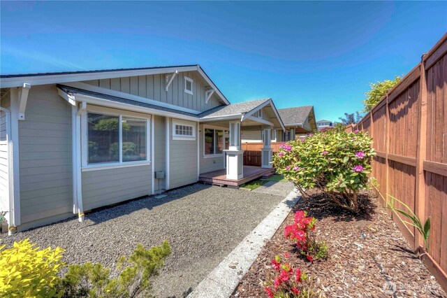 back of house featuring a fenced backyard and board and batten siding
