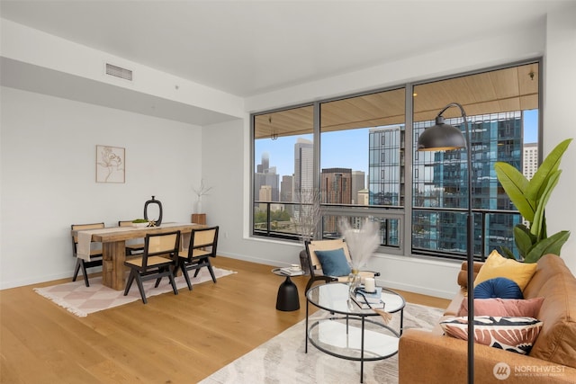 living area with plenty of natural light, wood finished floors, and visible vents