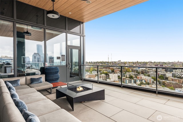 balcony featuring a view of city and an outdoor living space with a fire pit