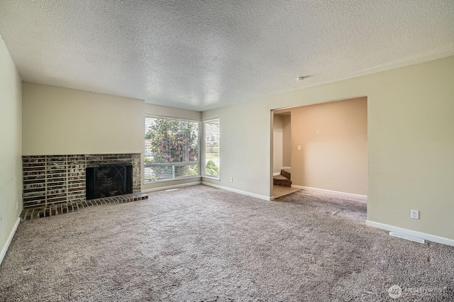unfurnished living room featuring baseboards, a textured ceiling, carpet, and a fireplace