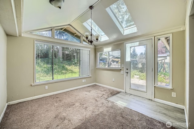 unfurnished sunroom with a notable chandelier and a skylight