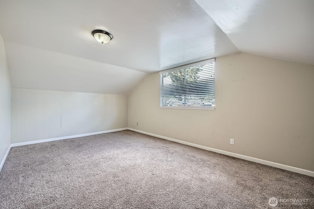 additional living space featuring carpet floors, baseboards, and lofted ceiling