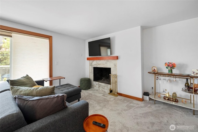 carpeted living room with baseboards and a high end fireplace