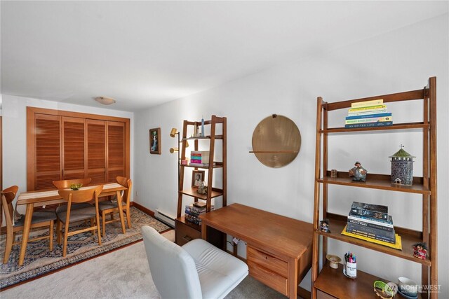 office space with carpet floors and a baseboard heating unit