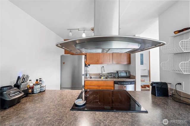 kitchen featuring brown cabinetry, a sink, appliances with stainless steel finishes, and dark countertops