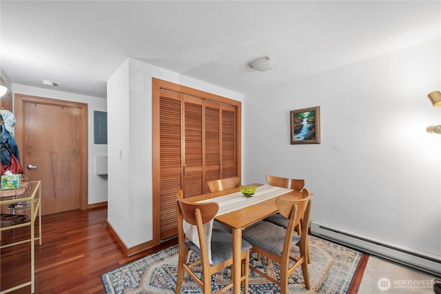 dining room featuring baseboards, wood finished floors, and baseboard heating