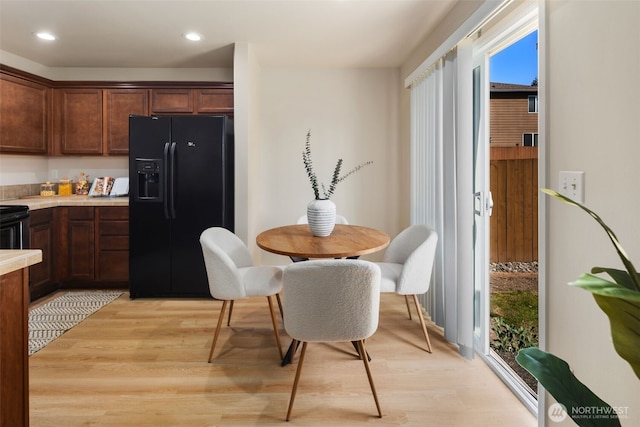 dining space with light wood-style floors and recessed lighting