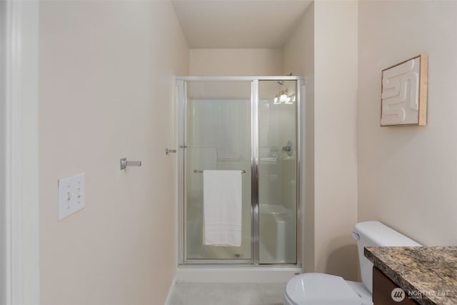 bathroom with tile patterned flooring, vanity, toilet, and a shower stall