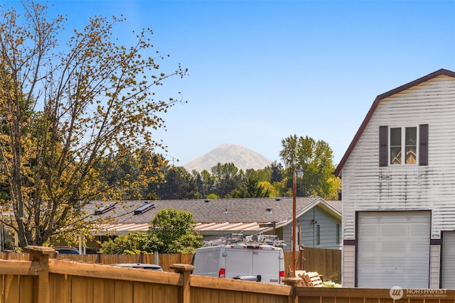 view of yard with a garage, a fenced backyard, and a mountain view