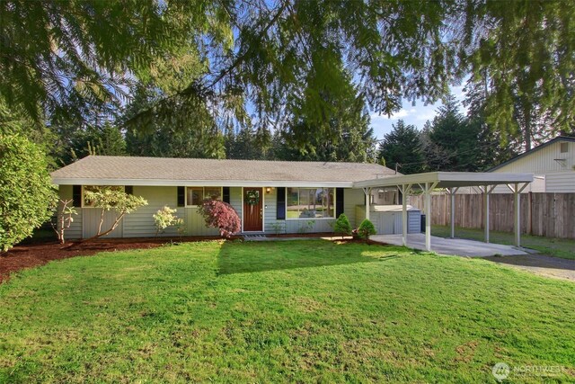ranch-style home featuring fence, a carport, driveway, and a front lawn