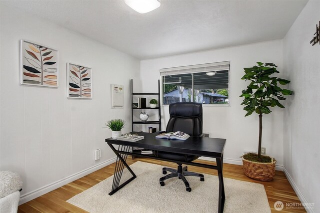 office area with baseboards and wood finished floors
