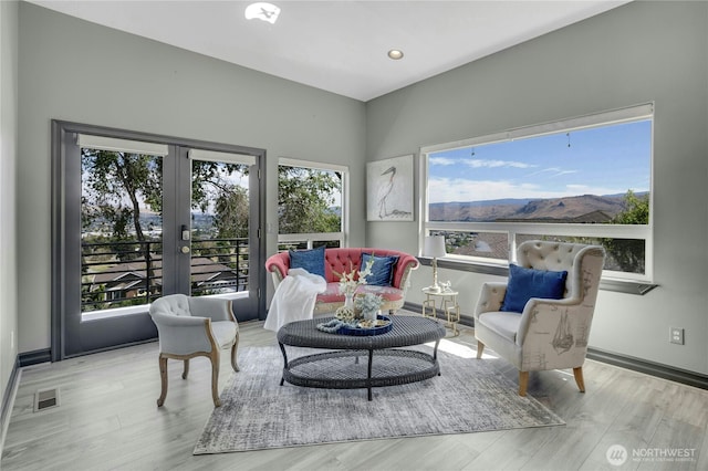 sitting room with visible vents, wood finished floors, a healthy amount of sunlight, and french doors