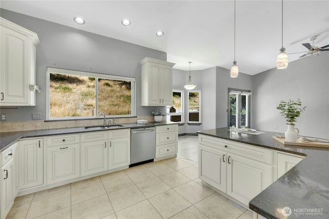 kitchen featuring stainless steel dishwasher, ceiling fan, a sink, light tile patterned floors, and hanging light fixtures