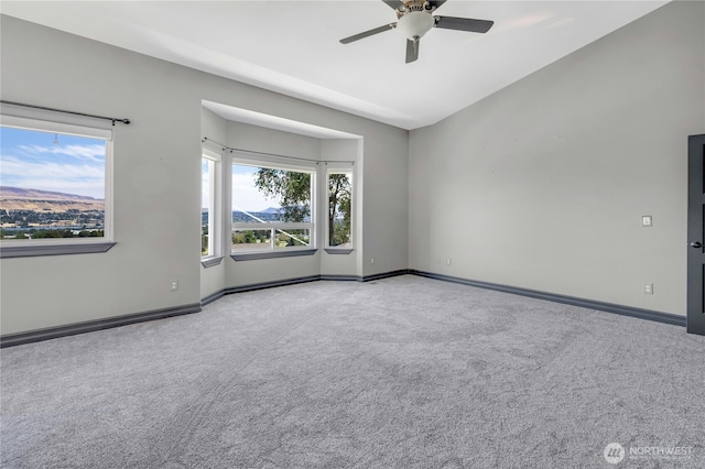 empty room featuring baseboards, carpet flooring, and ceiling fan