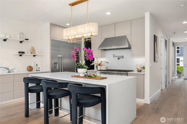 3968 162nd Pl SE, Bellevue, WA 98006 - kitchen featuring under cabinet range hood, light countertops, light wood-style floors, recessed lighting, and a kitchen island