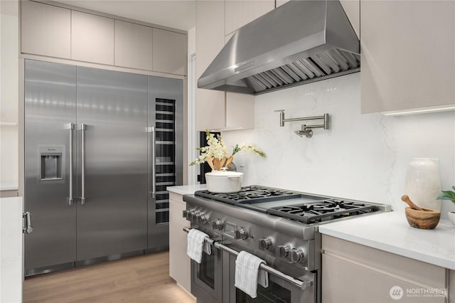 3968 162nd Pl SE, Bellevue, WA 98006 - kitchen with exhaust hood, high end appliances, light wood-type flooring, and decorative backsplash