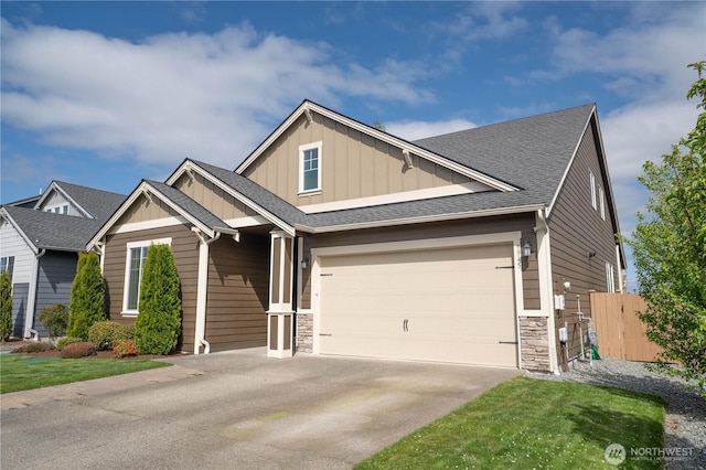 craftsman house featuring board and batten siding, fence, stone siding, and concrete driveway